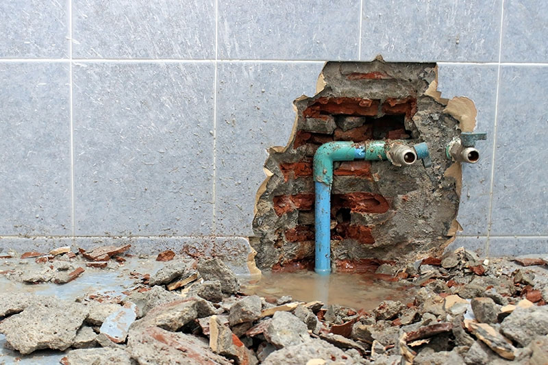 Floor and wall tiles broken revealing leaky water pipes